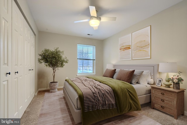 carpeted bedroom with ceiling fan and a closet