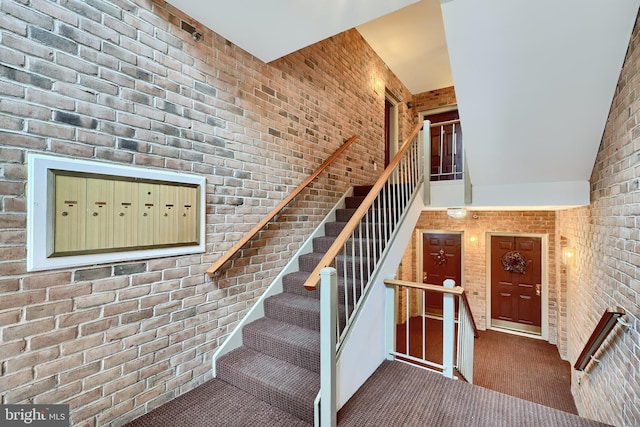 stairs with brick wall and carpet flooring