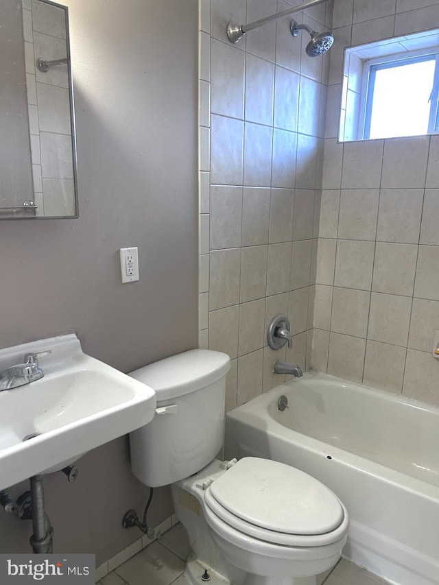 bathroom with toilet, tile patterned floors, and tiled shower / bath