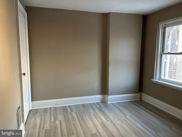 spare room with plenty of natural light and light hardwood / wood-style flooring