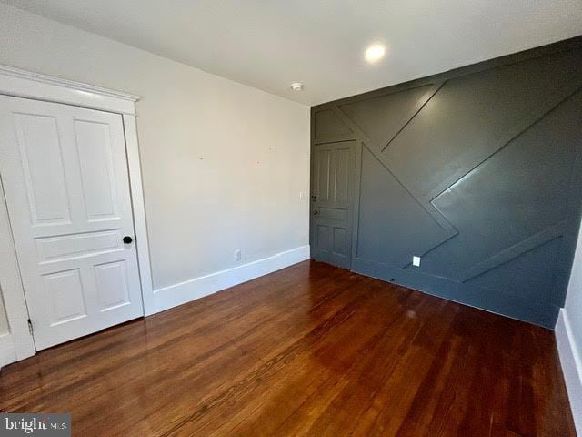 interior space with dark wood-style flooring and baseboards