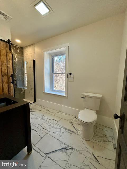 bathroom featuring a stall shower, marble finish floor, vanity, and baseboards