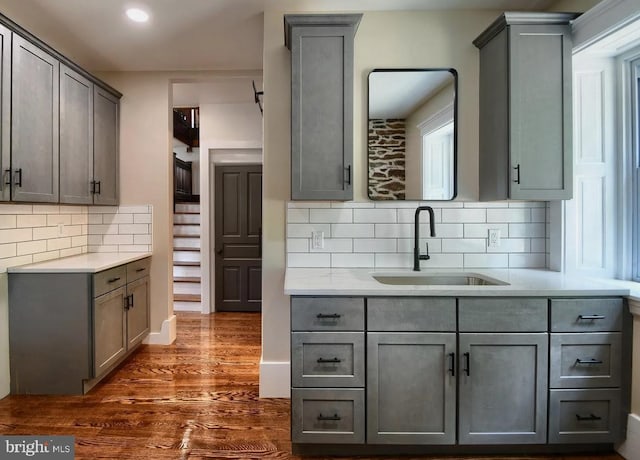 kitchen with light countertops, a sink, and gray cabinetry