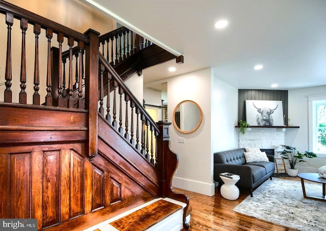 stairs featuring baseboards, wood finished floors, and recessed lighting