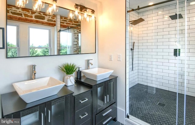 full bath with double vanity, a shower stall, and a sink