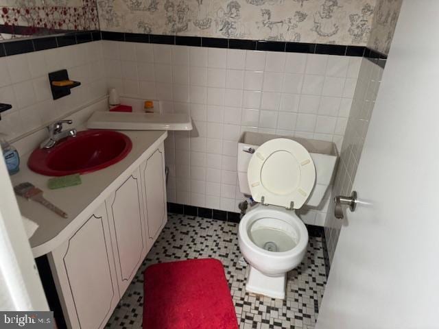 bathroom with tile walls, vanity, tile patterned floors, and toilet