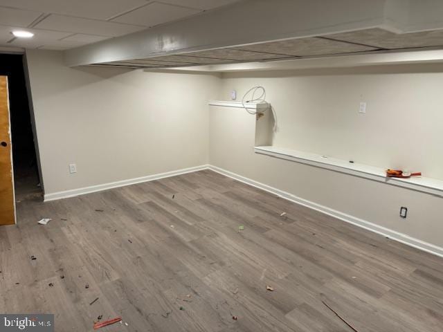 basement featuring hardwood / wood-style flooring and a paneled ceiling