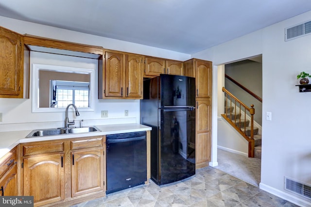 kitchen featuring black appliances, light carpet, and sink