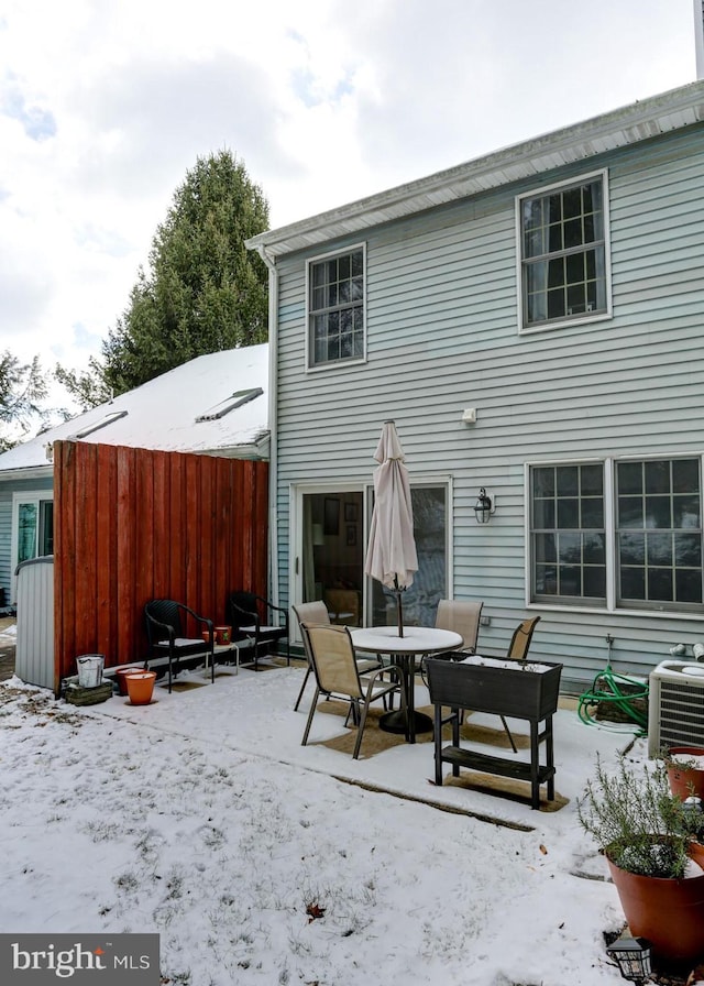 snow covered back of property featuring cooling unit