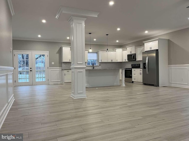 kitchen with white cabinets, decorative light fixtures, crown molding, and appliances with stainless steel finishes