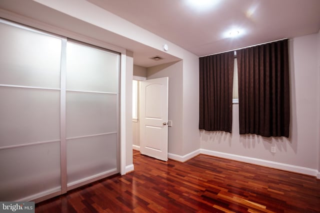 unfurnished bedroom with dark hardwood / wood-style flooring