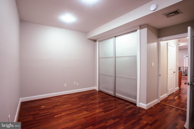 unfurnished bedroom with a closet and dark hardwood / wood-style floors