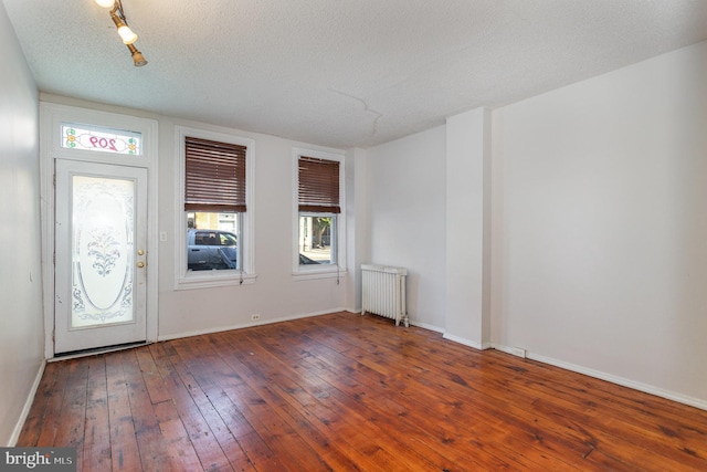 foyer with a textured ceiling, radiator, and dark hardwood / wood-style floors