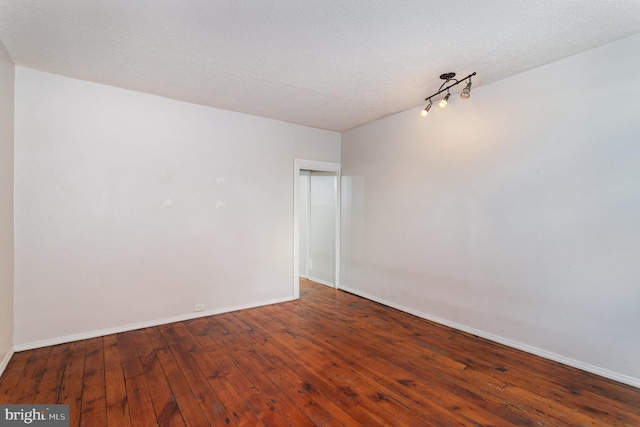 spare room featuring wood-type flooring and a textured ceiling