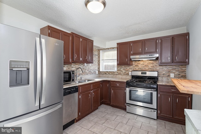 kitchen with decorative backsplash, appliances with stainless steel finishes, a textured ceiling, sink, and light tile patterned floors