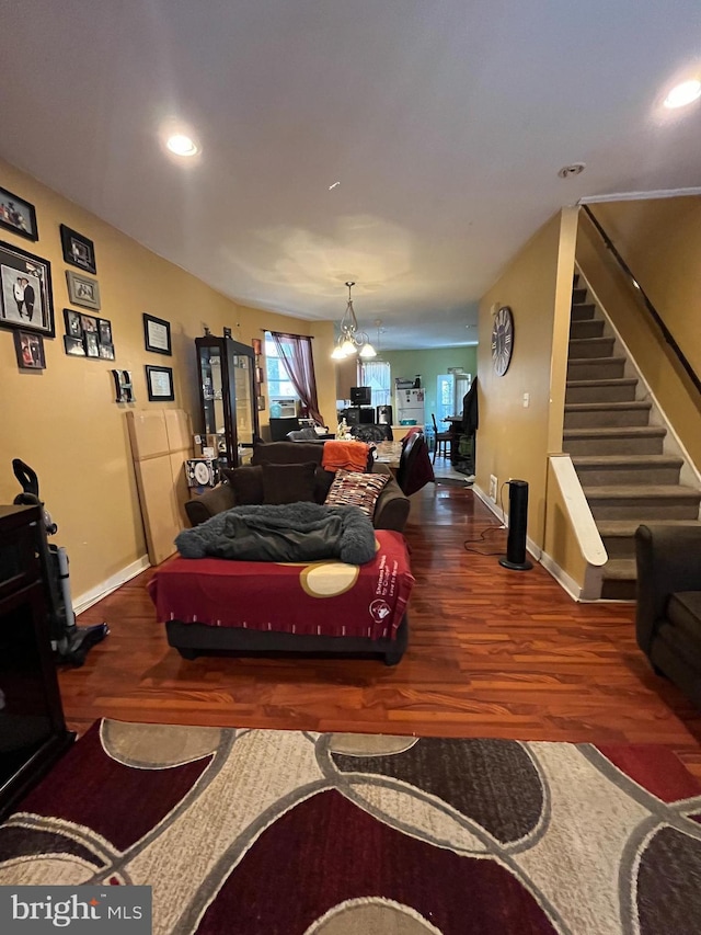 living room with a notable chandelier and dark hardwood / wood-style flooring