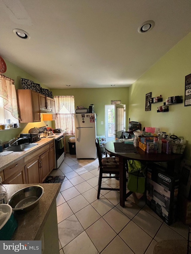 kitchen featuring range with electric stovetop, white refrigerator, sink, and light tile patterned floors