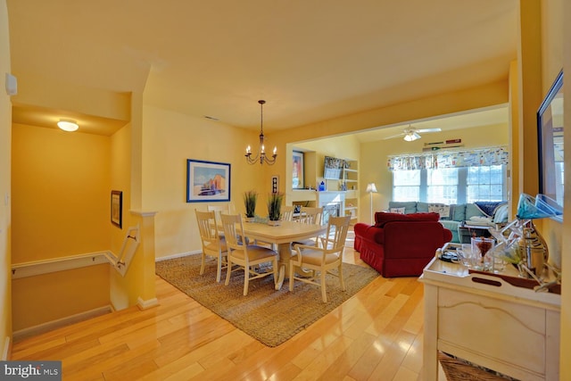 dining area featuring hardwood / wood-style floors and ceiling fan with notable chandelier