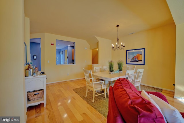 dining area featuring wood-type flooring and an inviting chandelier