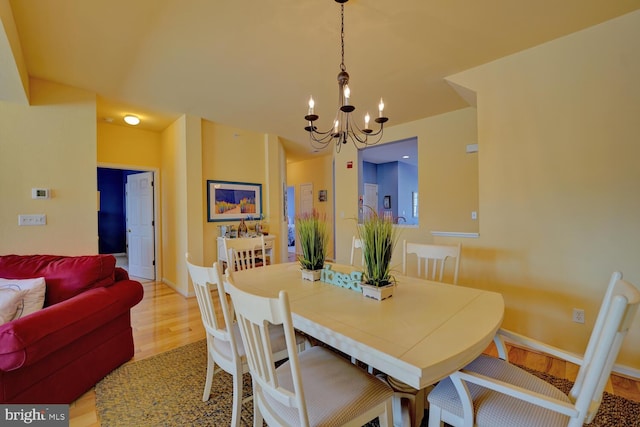 dining room with a chandelier and light wood-type flooring