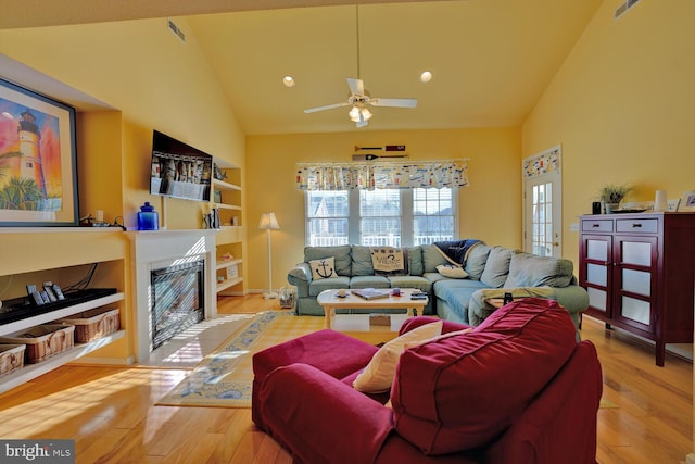 living room with ceiling fan, light hardwood / wood-style flooring, and high vaulted ceiling