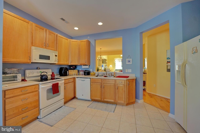 kitchen with light tile patterned floors, white appliances, a notable chandelier, and sink