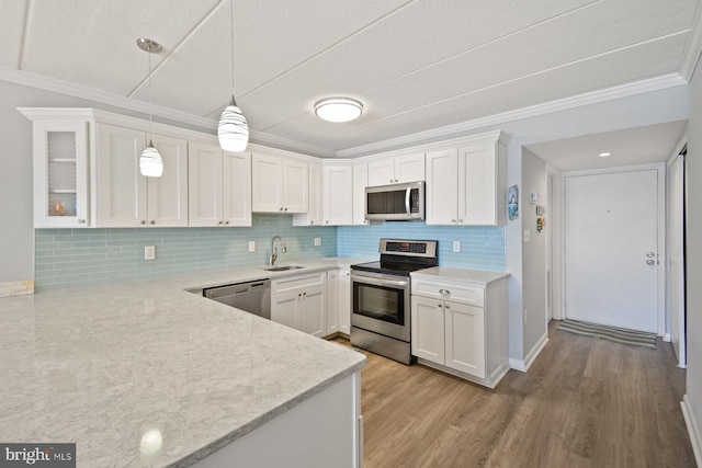 kitchen featuring white cabinets, hanging light fixtures, appliances with stainless steel finishes, and sink