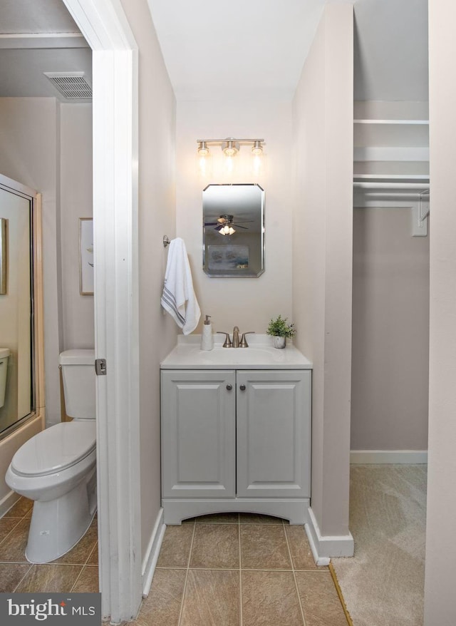 full bathroom featuring tile patterned flooring, vanity, bath / shower combo with glass door, and toilet