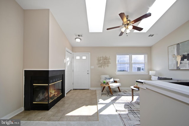 entryway with a multi sided fireplace, lofted ceiling, and ceiling fan