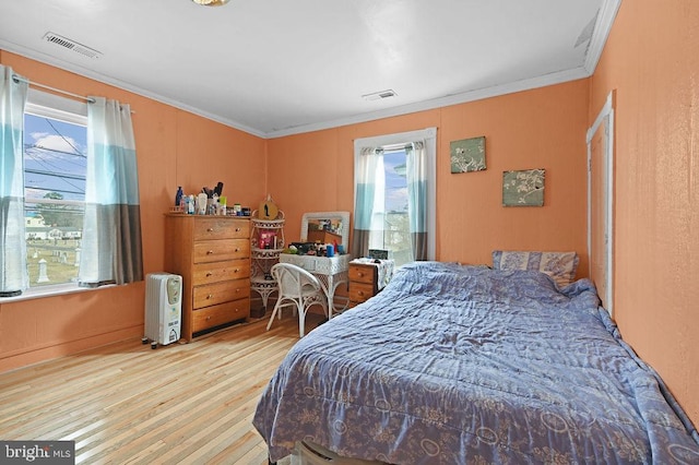 bedroom with light hardwood / wood-style floors and ornamental molding