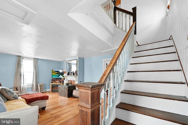 stairway with wood-type flooring and radiator