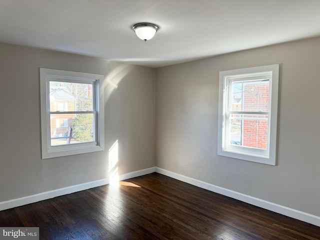 unfurnished room with dark hardwood / wood-style flooring