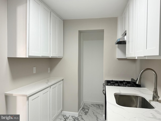 kitchen with sink, white cabinetry, and light stone countertops