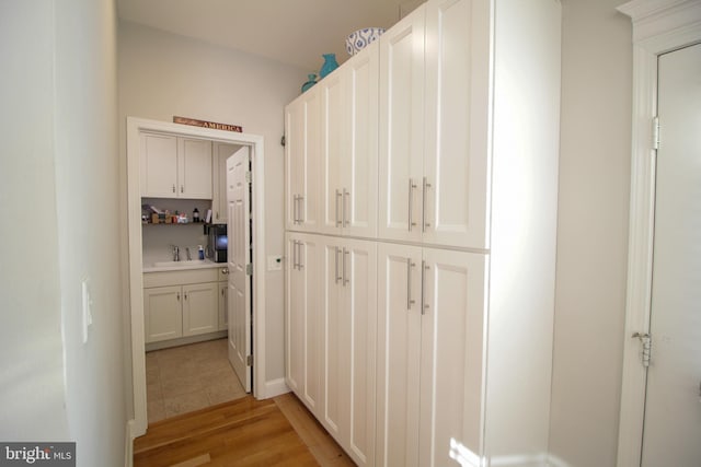 corridor with sink and light hardwood / wood-style floors