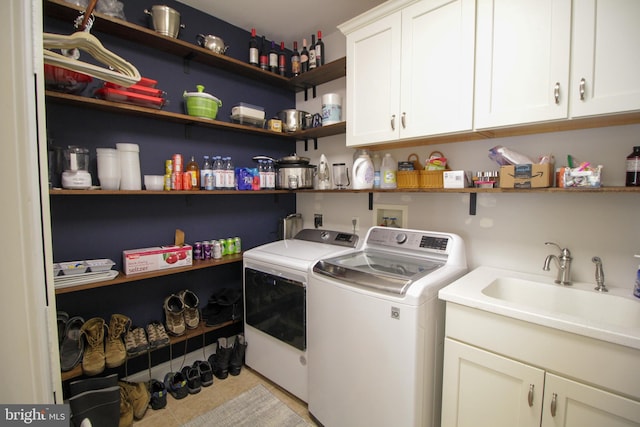 washroom with washing machine and clothes dryer, sink, light tile patterned floors, and cabinets