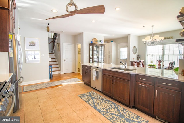 kitchen featuring dark brown cabinets, ceiling fan with notable chandelier, stainless steel appliances, sink, and decorative light fixtures