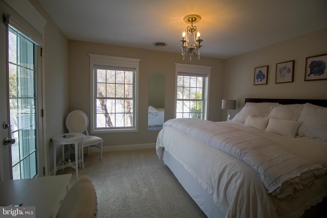 carpeted bedroom with multiple windows and a notable chandelier