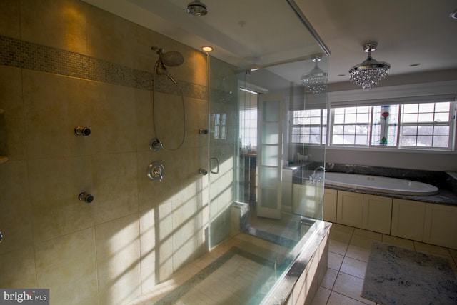 bathroom featuring tile patterned floors, independent shower and bath, and a notable chandelier