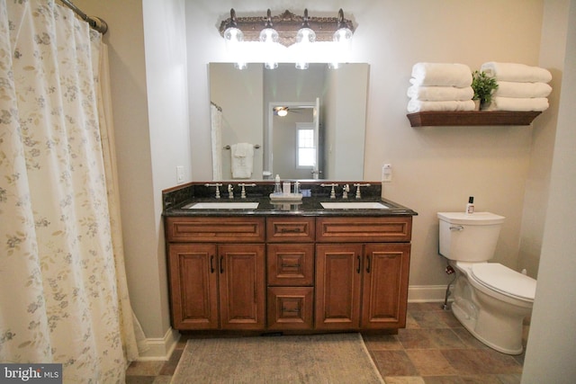 bathroom featuring a shower with curtain, ceiling fan, vanity, and toilet