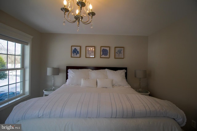 bedroom featuring multiple windows and a notable chandelier