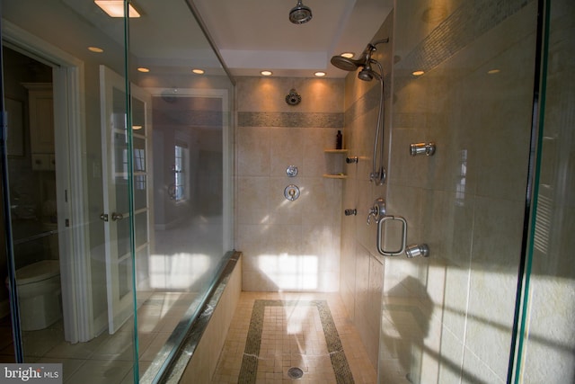 bathroom with an enclosed shower, toilet, and tile walls