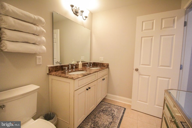 bathroom with tile patterned flooring, vanity, and toilet