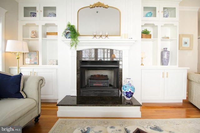 living area with hardwood / wood-style flooring and a tile fireplace