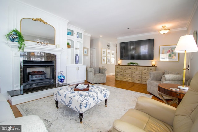 living room with a fireplace, ornamental molding, and light wood-type flooring