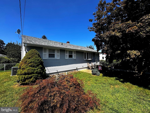 view of home's exterior with central AC and a yard