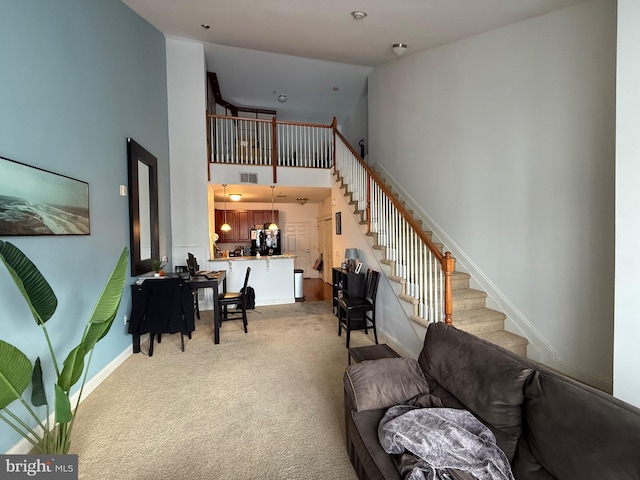 carpeted living room with high vaulted ceiling