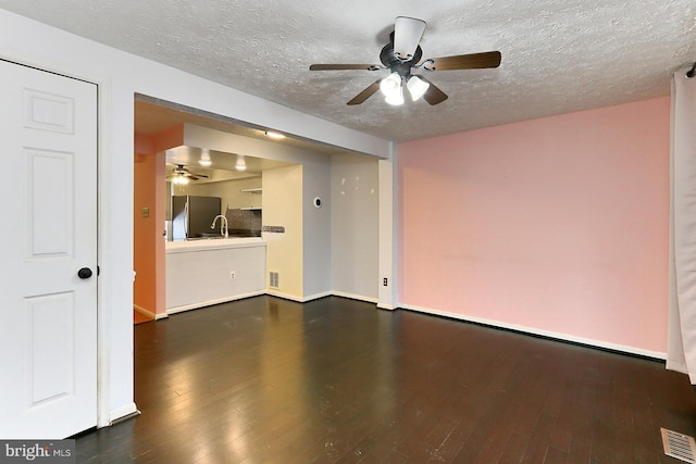 unfurnished living room featuring ceiling fan, dark hardwood / wood-style floors, and a textured ceiling