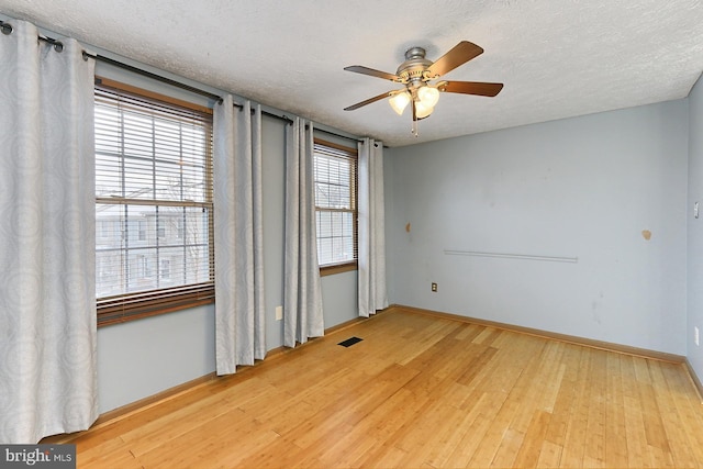 spare room featuring a textured ceiling, ceiling fan, and light hardwood / wood-style floors