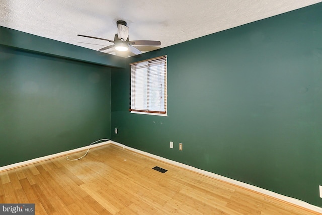 empty room featuring a textured ceiling, ceiling fan, and hardwood / wood-style flooring