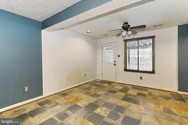 foyer with ceiling fan and a textured ceiling